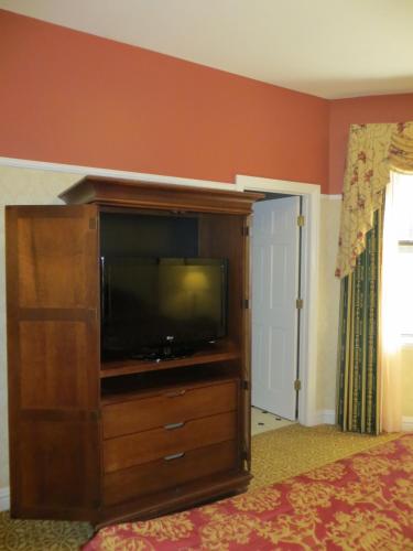 a entertainment center with a television in a bedroom at Carleton of Oak Park in Oak Park