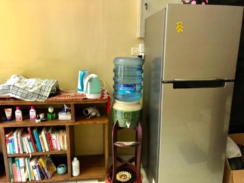 una nevera con una pila de contenedores de agua al lado en Guest house KupuKupu39, en Kuta