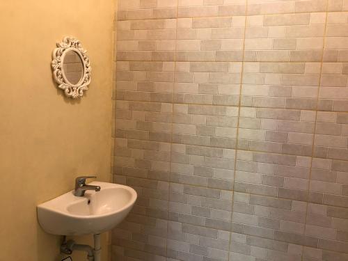 a bathroom with a sink and a mirror on the wall at Guest house KupuKupu39 in Kuta