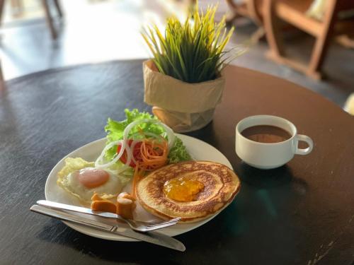 un plato de comida con un sándwich y una taza de café en To Zleep Hotel Khaolak, en Khao Lak