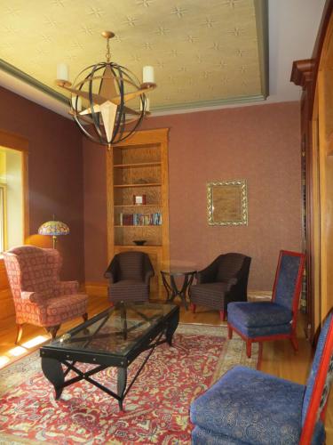 a living room with chairs and a table and a chandelier at Carleton of Oak Park in Oak Park