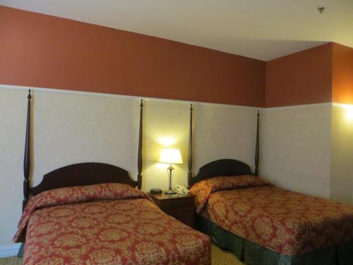 two beds in a hotel room with red walls at Carleton of Oak Park in Oak Park