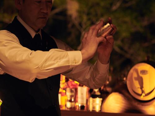 un hombre sosteniendo un pedazo de comida en sus manos en barhotel Hakone Kazan, en Hakone