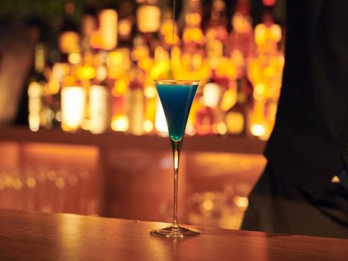 a blue drink in a martini glass sitting on a bar at barhotel Hakone Kazan in Hakone