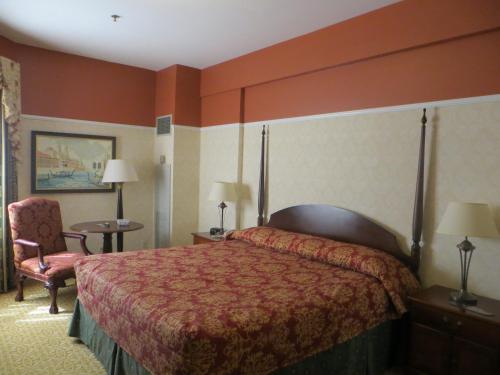 a hotel room with a bed and a chair at Carleton of Oak Park in Oak Park