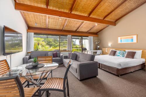 a living room with a bed and a couch at Nautilus Beachfront Villas & Spa in Coffs Harbour