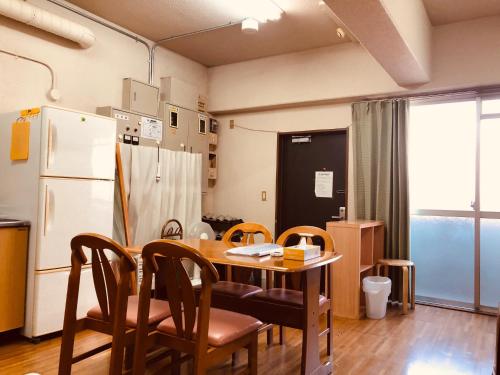 a kitchen with a table and chairs and a refrigerator at Nishijin Ivy in Kyoto