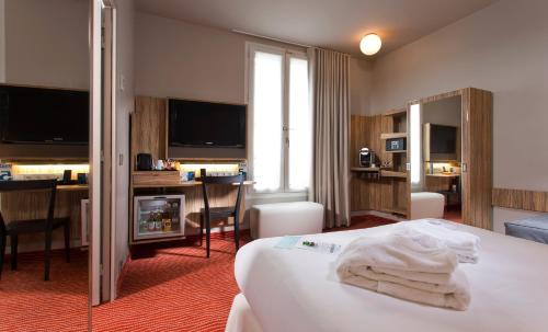 une chambre d'hôtel avec un lit et des serviettes blanches. dans l'établissement Libertel Gare de L'Est Francais, à Paris