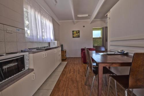 a kitchen with a table and a dining room at BIG4 Wangaratta North Cedars Holiday Park in Wangaratta