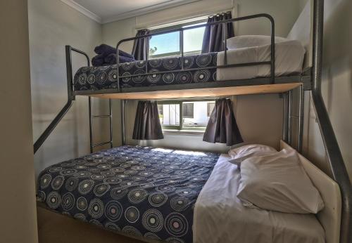 two bunk beds in a small room with a bed at BIG4 Wangaratta North Cedars Holiday Park in Wangaratta