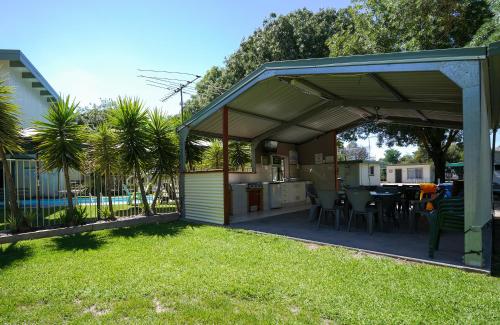 a covered patio with a table and a kitchen at BIG4 Wangaratta North Cedars Holiday Park in Wangaratta