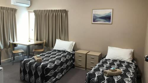 A bed or beds in a room at Aquatic Motor Inn