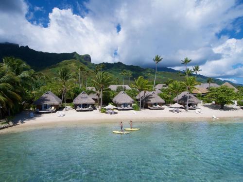 a person on a surfboard in the water on a beach at Manava Beach Resort & Spa Moorea in Maharepa