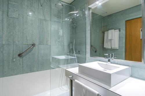 a bathroom with a white sink and a shower at The Azoriani Boutique, Ascend Hotel Collection in Ponta Delgada