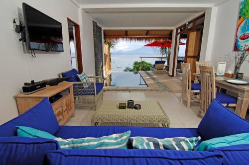 a living room with a blue couch and a table at Lembongan Sanctuary Villas in Nusa Lembongan