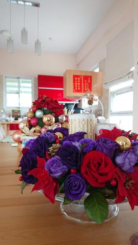 a table with a bouquet of flowers and a christmas tree at Straybirds in Donghe
