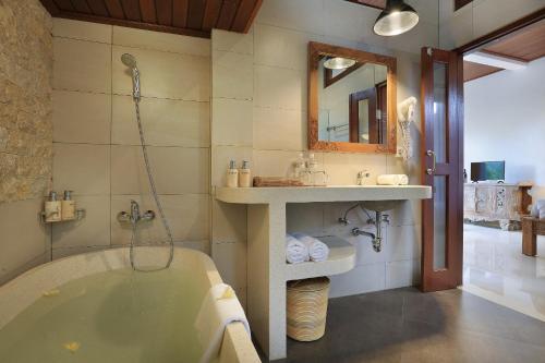 uma casa de banho com uma banheira, um lavatório e um espelho. em Ketut's Place Villas Ubud em Ubud