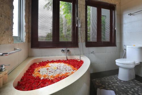 a bathroom with a bath tub covered in flowers at Ketut's Place Cottage Ubud in Ubud