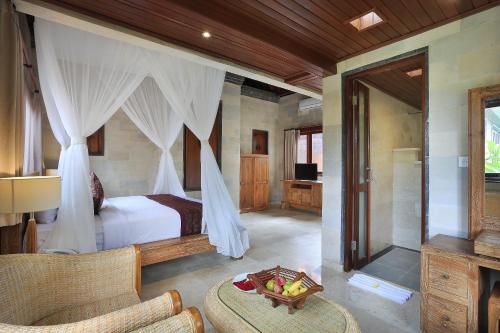 a bedroom with a bed with curtains and a couch at Ketut's Place Cottage Ubud in Ubud