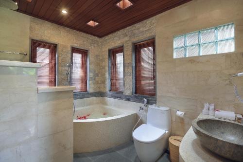a bathroom with a tub and a toilet and a sink at Ketut's Place Cottage Ubud in Ubud