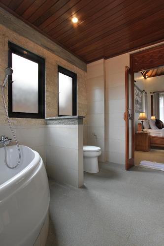a bathroom with a toilet and a tub and a sink at Ketut's Place Cottage Ubud in Ubud