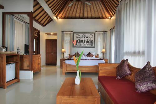a bedroom with a bed and a couch in a room at Ketut's Place Villas Ubud in Ubud