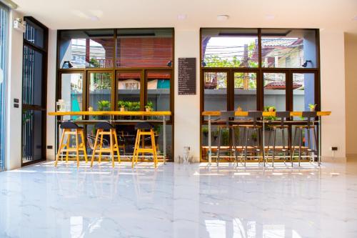 a bar with stools in front of a building at Rich8 Hostel in Bangkok