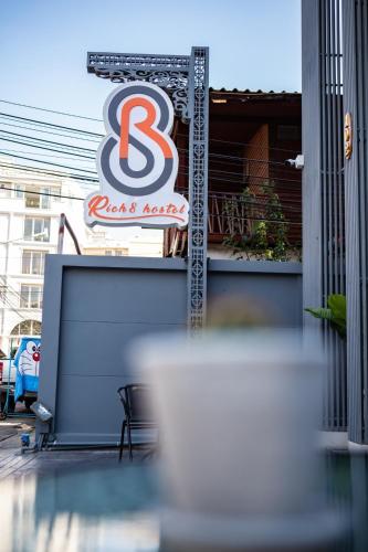 a restaurant with a sign on the side of a building at Rich8 Hostel in Bangkok