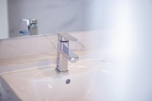 a bathroom sink with a silver faucet at Rich8 Hostel in Bangkok