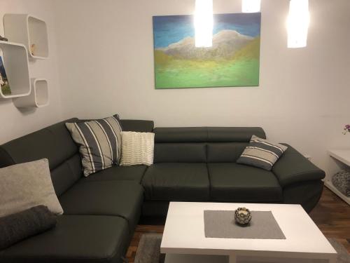 a living room with a green couch and a table at Haus Mup in Spittal an der Drau