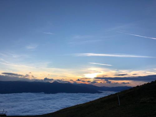 a view of the sun rising above the clouds in the mountains at Haus Mup in Spittal an der Drau
