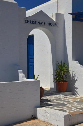 a white building with a blue door and a house at Christina's House in Koufonisia