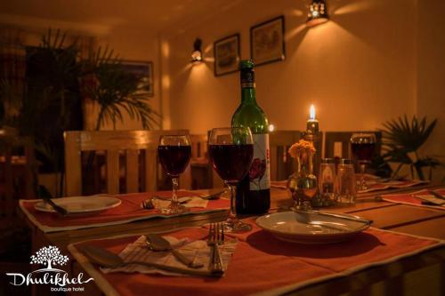 a table with wine glasses and a bottle of wine at Dhulikhel boutique hotel in Dhulikhel