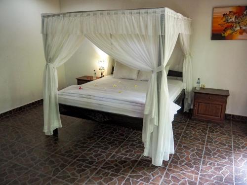 a bedroom with a bed with a canopy at Scuba Tribe Bali dive-resort in Tulamben