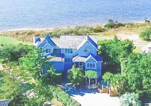 a blue house on the shore of the water at Doggone Perfect - Village at Nags Head, Soundfront, Golf Course View, Pool, Hot Tub, Pets OK, Flex Stays in Nags Head