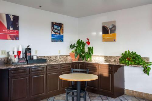 a kitchen with brown cabinets and a wooden table at Motel 6-Wilsonville, OR - Portland in Wilsonville