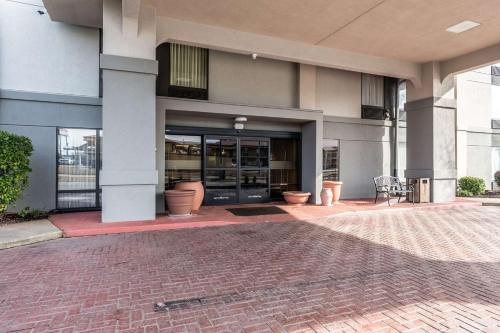 a building with a brick walkway in front of it at Motel 6-Conway, AR in Conway
