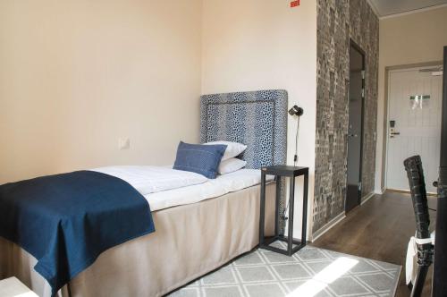 a bedroom with a bed with blue pillows on it at Statt Hassleholm BW Signature Collection in Hässleholm