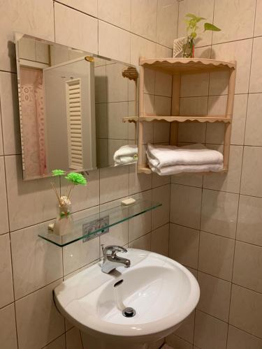 a bathroom with a sink and a mirror and towels at Miao Fu Homestay in Xiaoliuqiu