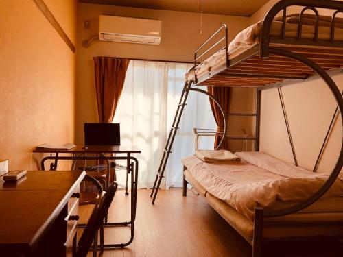 a dorm room with a bunk bed and a desk at Nishijin Ivy in Kyoto