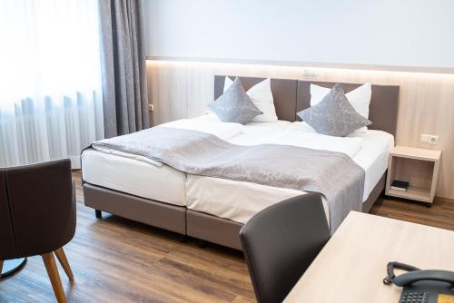 a hotel room with a large bed with pillows at Hotel-Gasthof Weisses Ross in Schwaig bei Nürnberg
