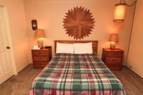 a bedroom with a bed with a plaid bedspread at Discovery 4 #125 in Mammoth Lakes