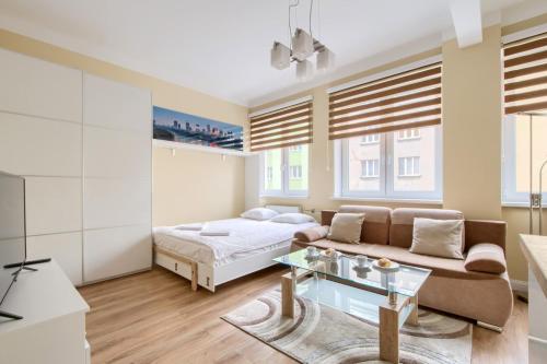 un soggiorno con un letto e un divano di Studio Tamka by BookingHost a Varsavia