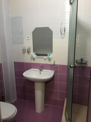 a bathroom with a sink and a mirror and a toilet at Гостиница ШАНЫРАК in Qyzylorda