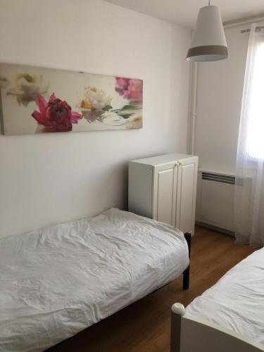 une chambre avec un lit et un tableau au mur dans l'établissement APPARTEMENT Deux chambres Salon Parking Rouen Kindarena, à Rouen
