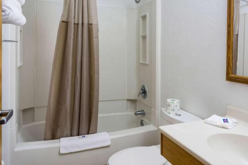 a bathroom with a toilet and a tub and a sink at Motel 6-Wilsonville, OR - Portland in Wilsonville