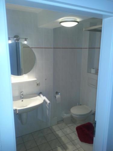 a bathroom with a sink and a toilet and a mirror at Ratskeller Nörten in Nörten-Hardenberg