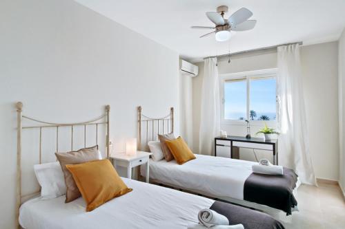 two beds in a bedroom with a window at Del Parque Flats - Torrevigia in Cala del Moral