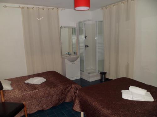 a bathroom with two beds and a shower and a sink at Hotel U Liccedu in Bustanico