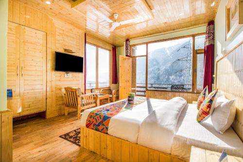 a bedroom with a bed with a view of a mountain at FabExpress Shami Inn Naggar Road in Manāli